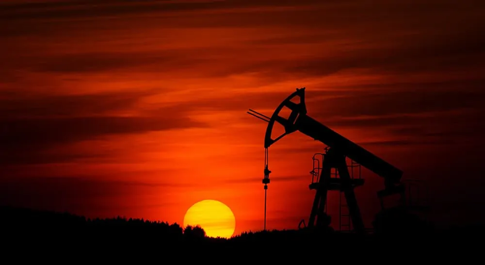 Image of an oil well at sunset