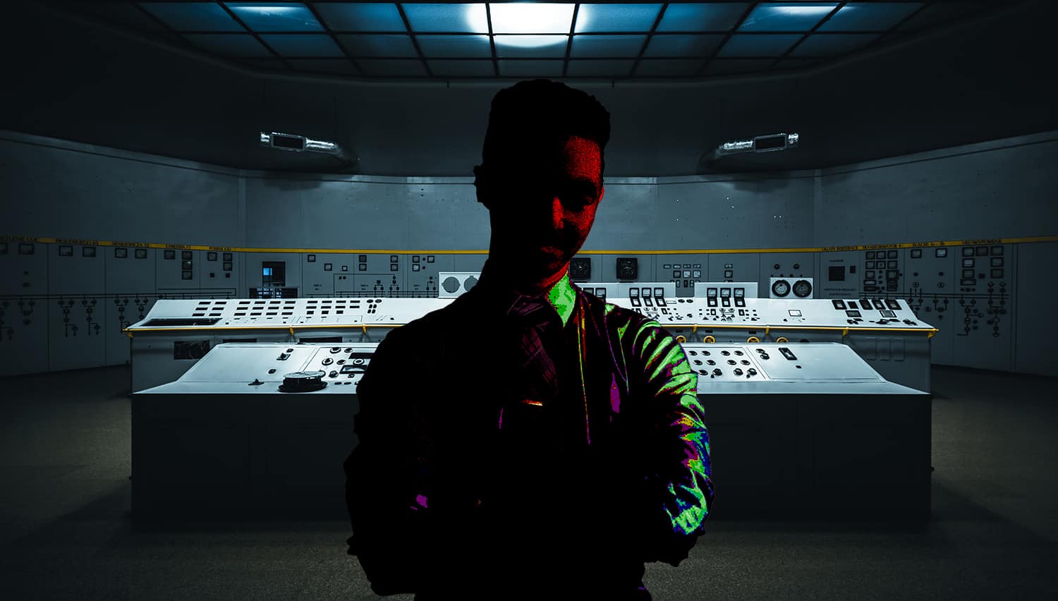 Image of a man covered in shadows inside of a control room